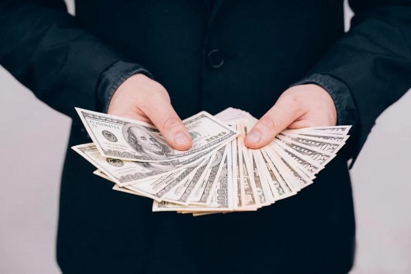 Man in suit holding Lawsuit Loan money