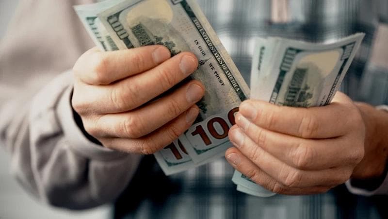 Hands of man counting pre-settlement funding cash