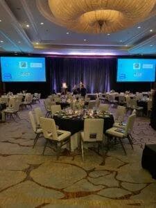 Configuración del salón para un evento con mesas y sillas.