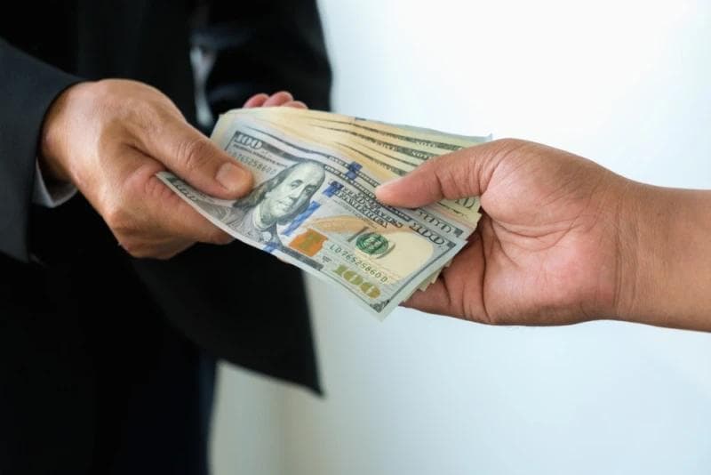 Man in suit handing Lawsuit Loan money