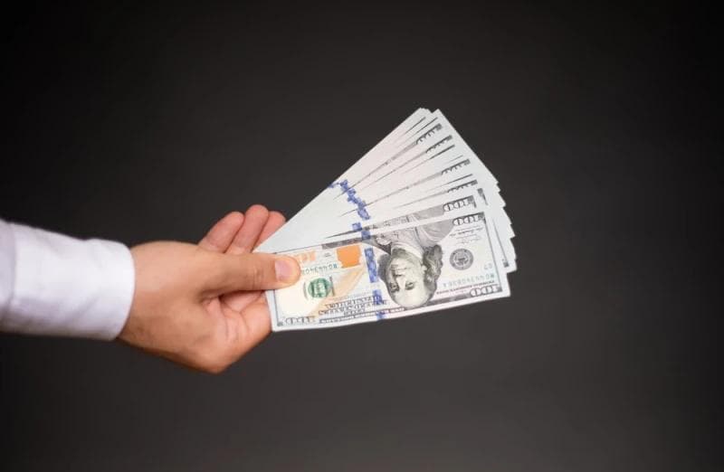 Man in white shirt handing Lawsuit Loan money