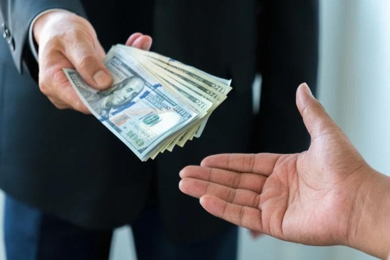 Man in suit handing Lawsuit Loan money