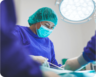 For Medical Providers. A female medical professional in surgical gear is working over a patient on a surgical table. She is holding a surgical tool. Rockpoint legal funding provides best in industry medical lien services.