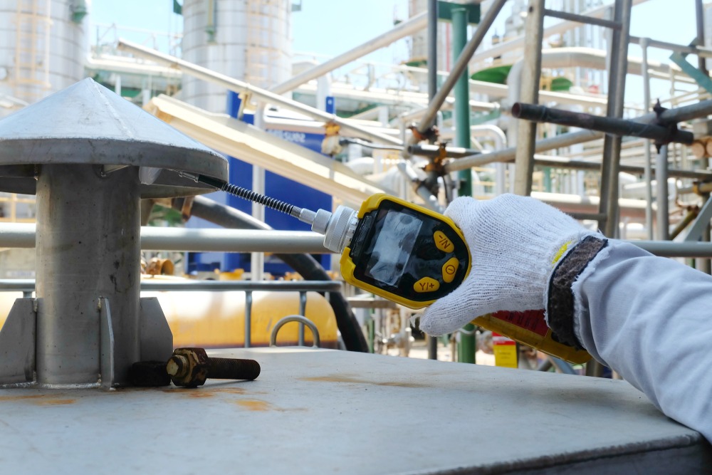 A gloved hand is shown holding a measurement instrument in an industrial looking setting. Rockpoint Legal Funding provides pre-settlement loans to plaintiffs in toxic exposure lawsuits.