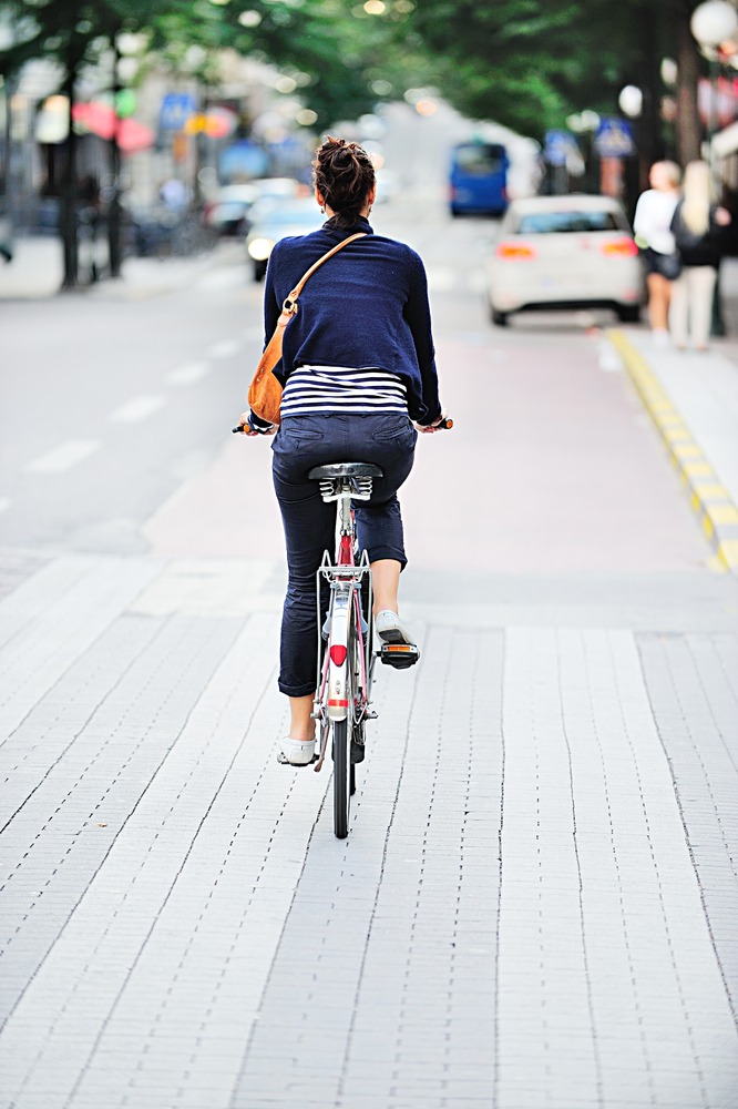 A woman riding a bicycle is viewed from behind. Rockpoint Legal Funding provides cash for platiffs who have been injured in bicycle accidents.