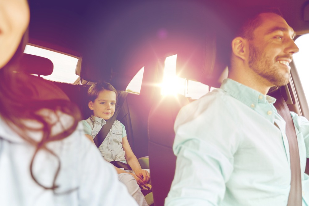 A family rides in a car. Mother, father and child are seen from the inside of the car, looking from front to back. The sun is setting in the background. Rockpoint Legal Funding provides lawsuit loans to plaintiffs in motor vehicle accident lawsuits.