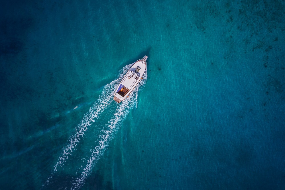 A view of a boat sailing through clear blue water as seen from above. Rockpoint Legal Funding is a top provider of plaintiff funding for people injured in boating accidents.