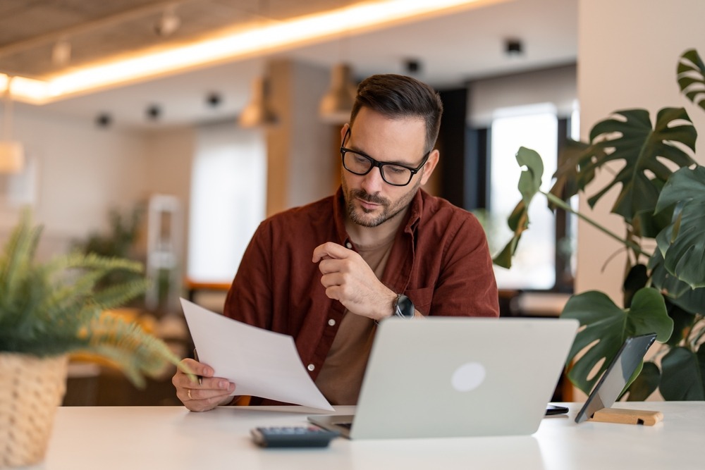 man reviewing his budget at his computer